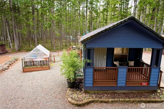 view of front facade featuring an exterior structure, an outbuilding, and a porch