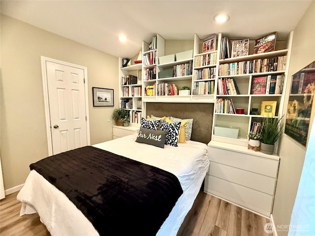 bedroom with recessed lighting, baseboards, lofted ceiling, and wood finished floors