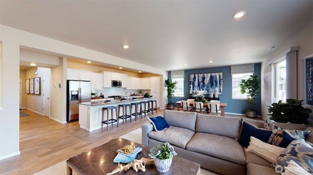 living area with recessed lighting, baseboards, and light wood finished floors