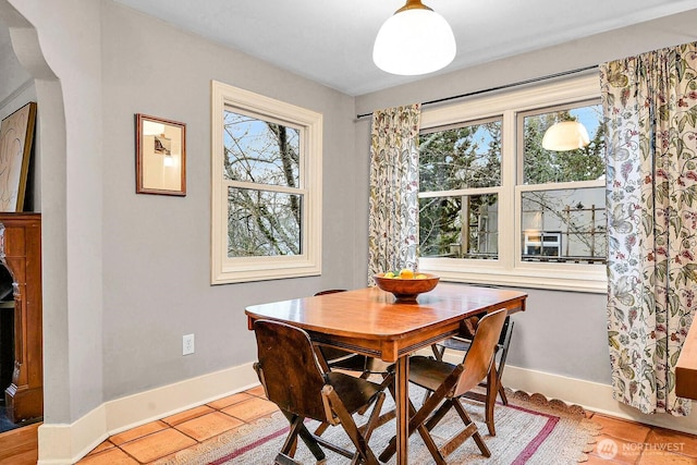 dining area featuring light tile patterned floors, plenty of natural light, and baseboards