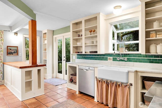 kitchen with open shelves, a sink, stainless steel dishwasher, tasteful backsplash, and butcher block counters