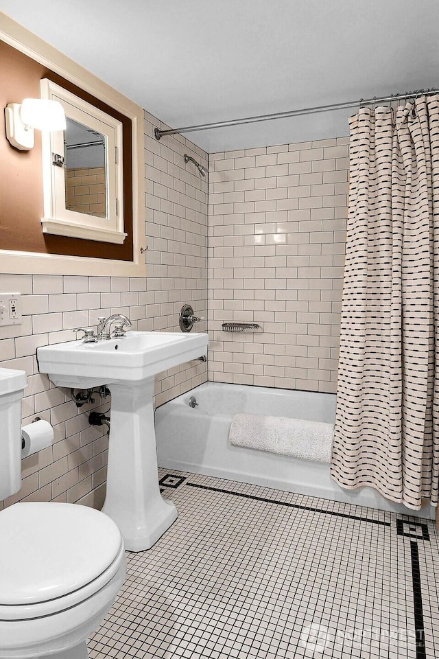 full bath featuring toilet, tile walls, shower / bath combination with curtain, and tile patterned flooring