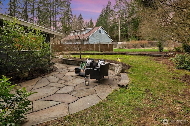 patio terrace at dusk with a lawn and fence