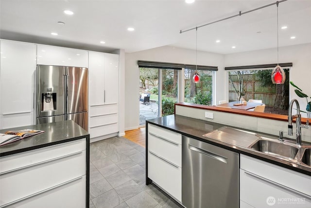 kitchen featuring white cabinetry, dark countertops, recessed lighting, and appliances with stainless steel finishes