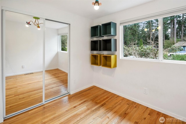 interior space with visible vents, light wood-style flooring, and baseboards