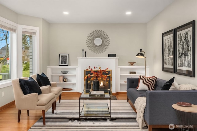 living area featuring recessed lighting, baseboards, a healthy amount of sunlight, and wood finished floors