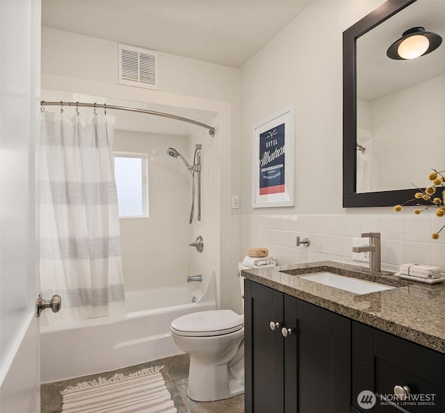 bathroom featuring vanity, visible vents, shower / bath combination with curtain, tile walls, and toilet