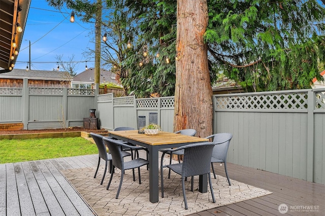 wooden terrace featuring outdoor dining space and a fenced backyard