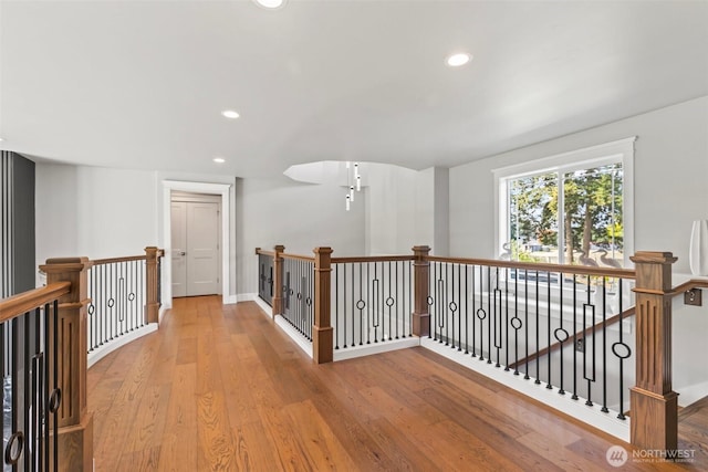 corridor featuring an upstairs landing, recessed lighting, light wood-type flooring, and baseboards