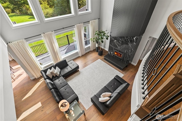 living area with a healthy amount of sunlight, wood finished floors, and stairs