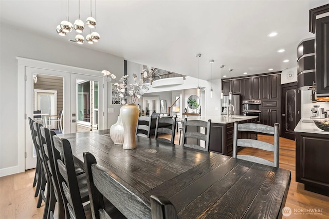 dining room with recessed lighting, french doors, baseboards, and light wood-style floors