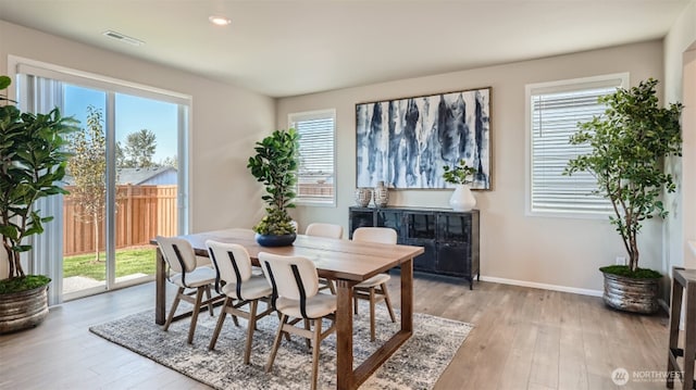 dining space with plenty of natural light, light wood-style floors, and visible vents