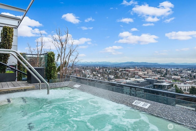 view of pool with a mountain view and a hot tub