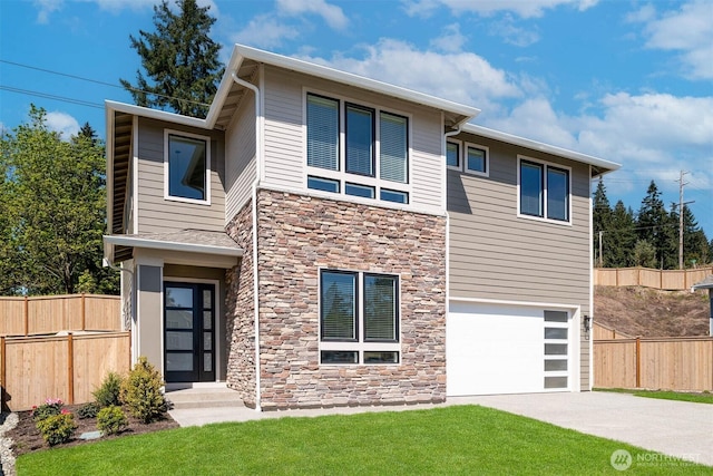 contemporary house featuring a front lawn, fence, concrete driveway, a garage, and stone siding