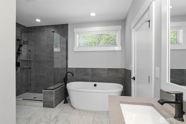 full bathroom featuring a freestanding bath, marble finish floor, and a stall shower