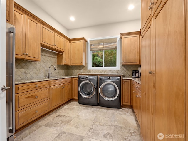 washroom featuring a sink, cabinet space, and washer and clothes dryer