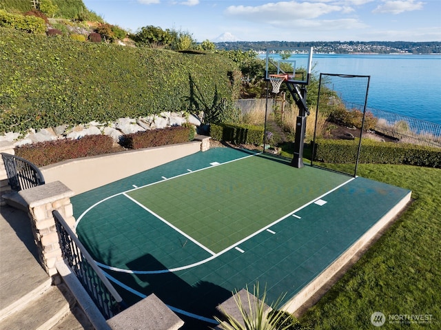 view of sport court with basketball court, a water view, and fence