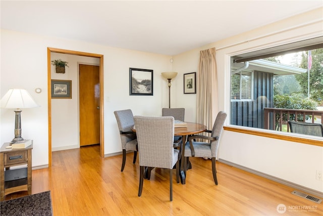 dining area with visible vents, baseboards, and light wood finished floors