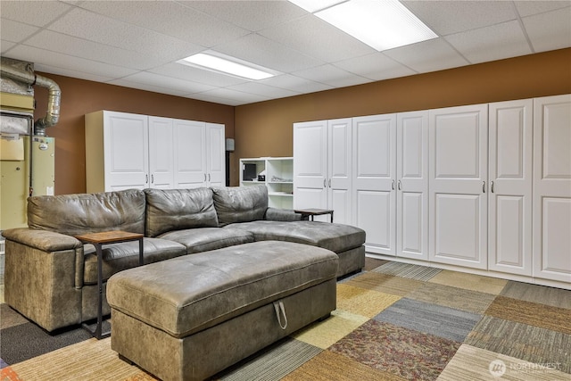 living room with a drop ceiling and light colored carpet