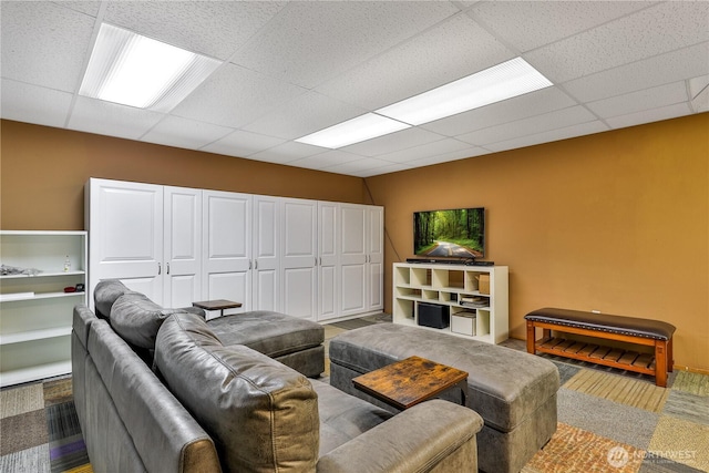 living room with a drop ceiling and baseboards