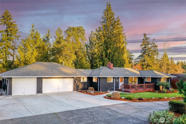 ranch-style house featuring an attached garage, a shingled roof, a chimney, concrete driveway, and board and batten siding