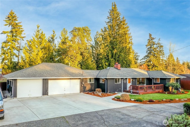 ranch-style home with driveway, roof with shingles, board and batten siding, a garage, and a chimney