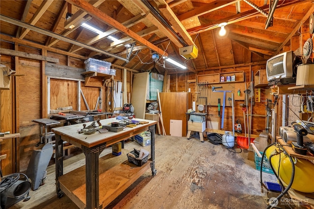 misc room featuring vaulted ceiling, a workshop area, and a garage