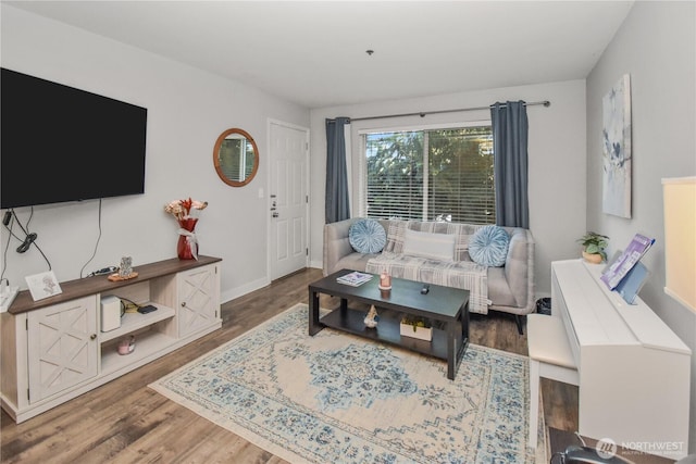 living area with baseboards and wood finished floors