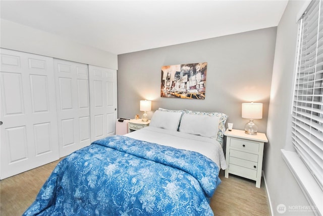 bedroom featuring a closet, baseboards, and wood finished floors