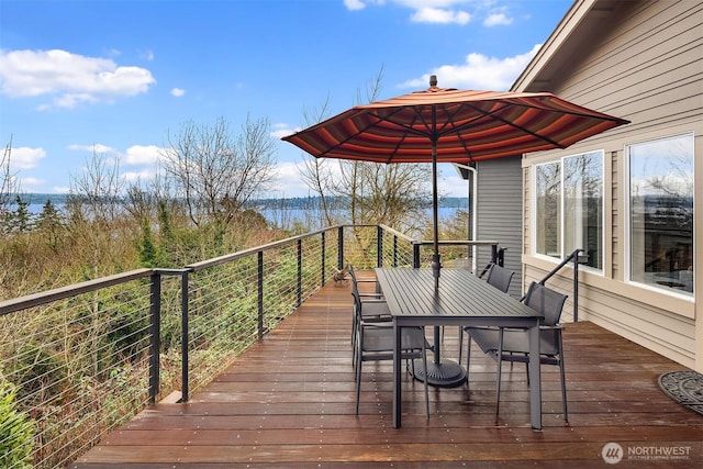 wooden deck with outdoor dining space and a water view