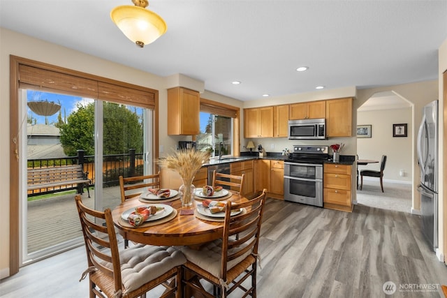 kitchen featuring a sink, dark countertops, recessed lighting, stainless steel appliances, and light wood finished floors