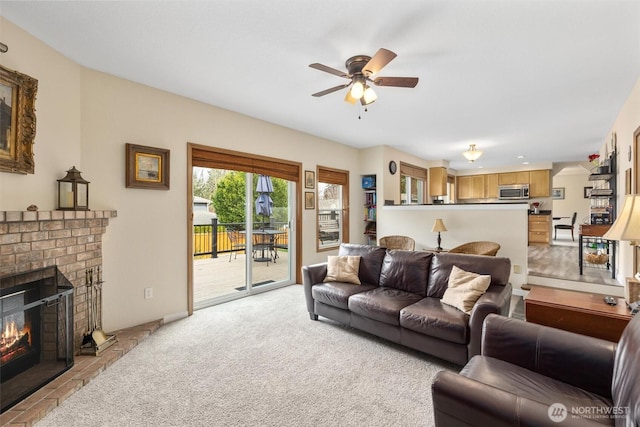 living room featuring light carpet, a brick fireplace, and ceiling fan