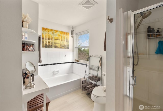 full bathroom featuring a garden tub, toilet, visible vents, and a stall shower