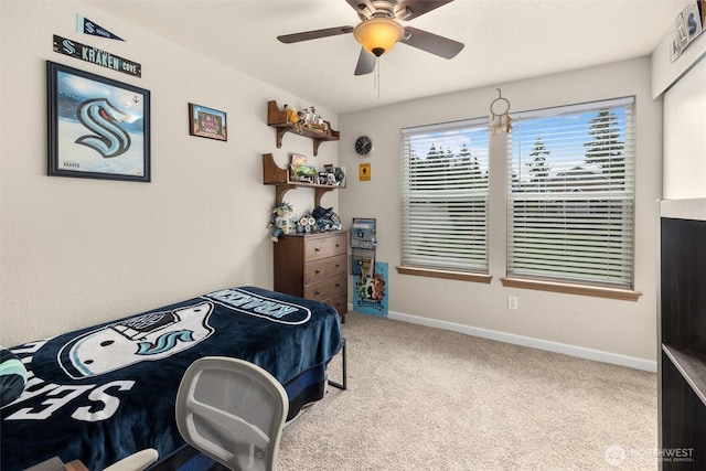 carpeted bedroom with ceiling fan and baseboards