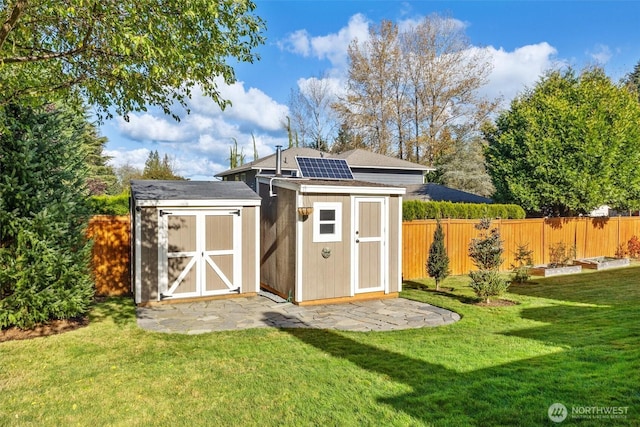 view of shed featuring solar panels and a fenced backyard