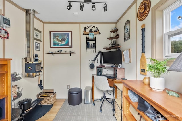 home office featuring track lighting, wood finished floors, ornate columns, and ornamental molding