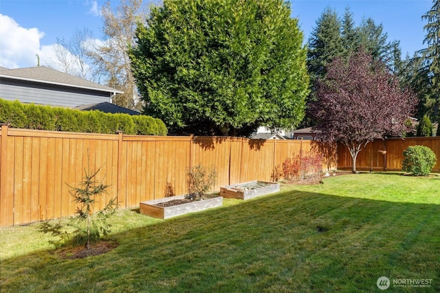 view of yard with a vegetable garden and a fenced backyard