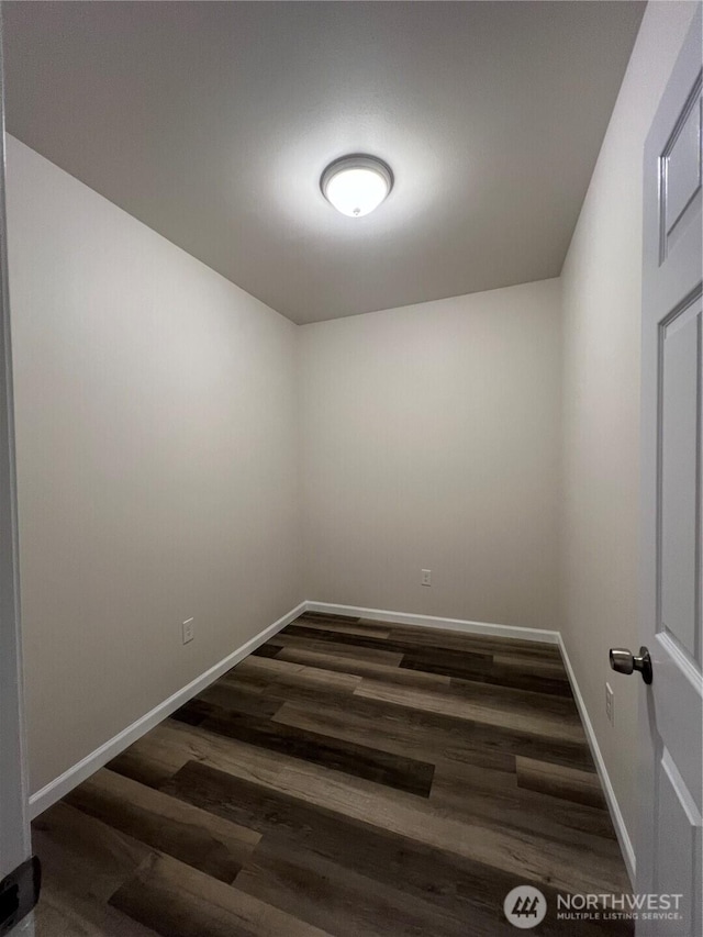 unfurnished room with dark wood-style floors and baseboards