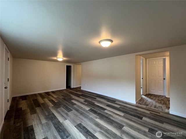 spare room featuring wood finished floors and baseboards