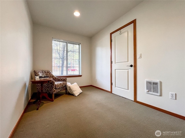 living area with heating unit, baseboards, and carpet