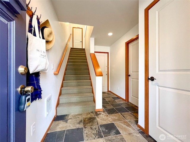 stairway with recessed lighting, visible vents, baseboards, and stone finish floor