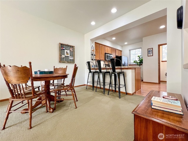 dining room featuring recessed lighting, baseboards, and light colored carpet