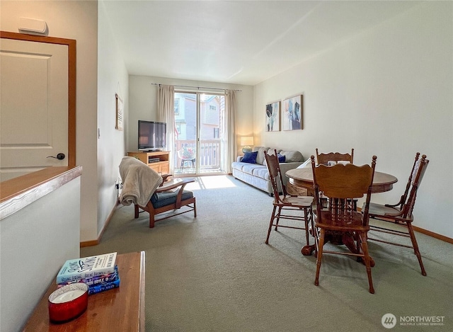 carpeted dining room with baseboards