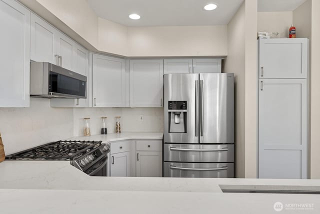 kitchen with light countertops, backsplash, recessed lighting, and appliances with stainless steel finishes