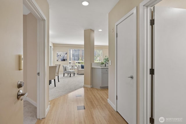 hall with recessed lighting, baseboards, and light wood finished floors