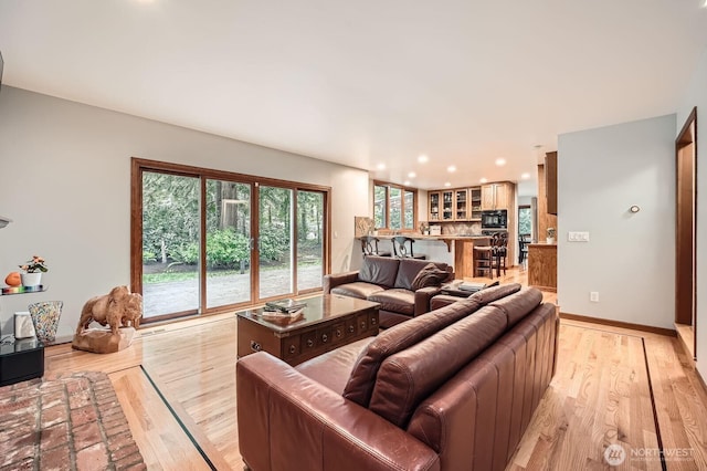 living area featuring recessed lighting, baseboards, and light wood finished floors