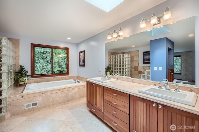 bathroom featuring a sink, visible vents, a healthy amount of sunlight, and a skylight