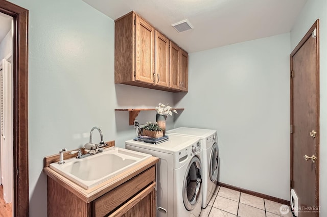 laundry room with visible vents, light tile patterned floors, washer and dryer, cabinet space, and a sink