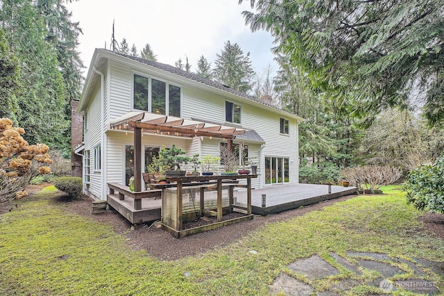 back of property featuring a yard, a deck, a chimney, and a pergola