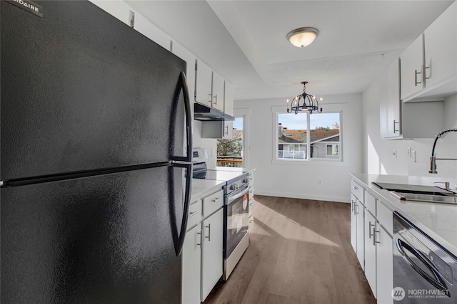 kitchen featuring black appliances, a sink, under cabinet range hood, light countertops, and dark wood-style flooring